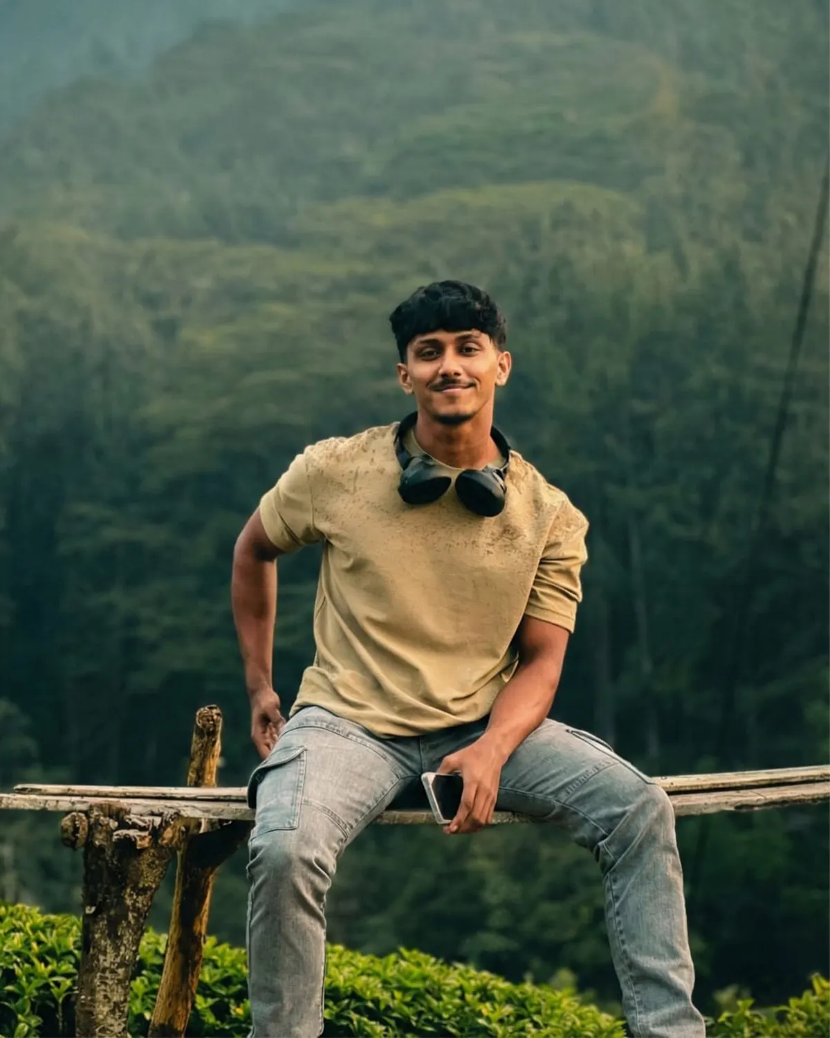 Thinura Anjana sitting on a wooden rail in the hill country